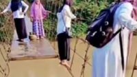 Guru di Kabupaten Merangin melewati jembatan gantung rusak