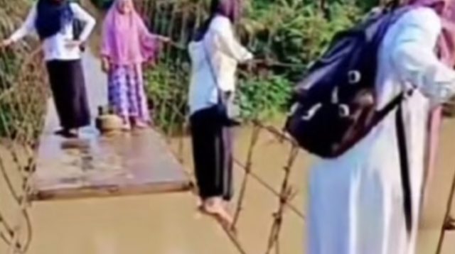 Guru di Kabupaten Merangin melewati jembatan gantung rusak