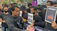 Puluhan wartawan menggelar demo dengan mulut dilakban hitam di Mapolda Jambi.