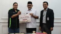 20251210_144926 Direktur Operasional Bank Jambi, Zulfikar menyerahkan bantuan dana untuk korban bencana alam melalui pemerintah provinsi Jambi