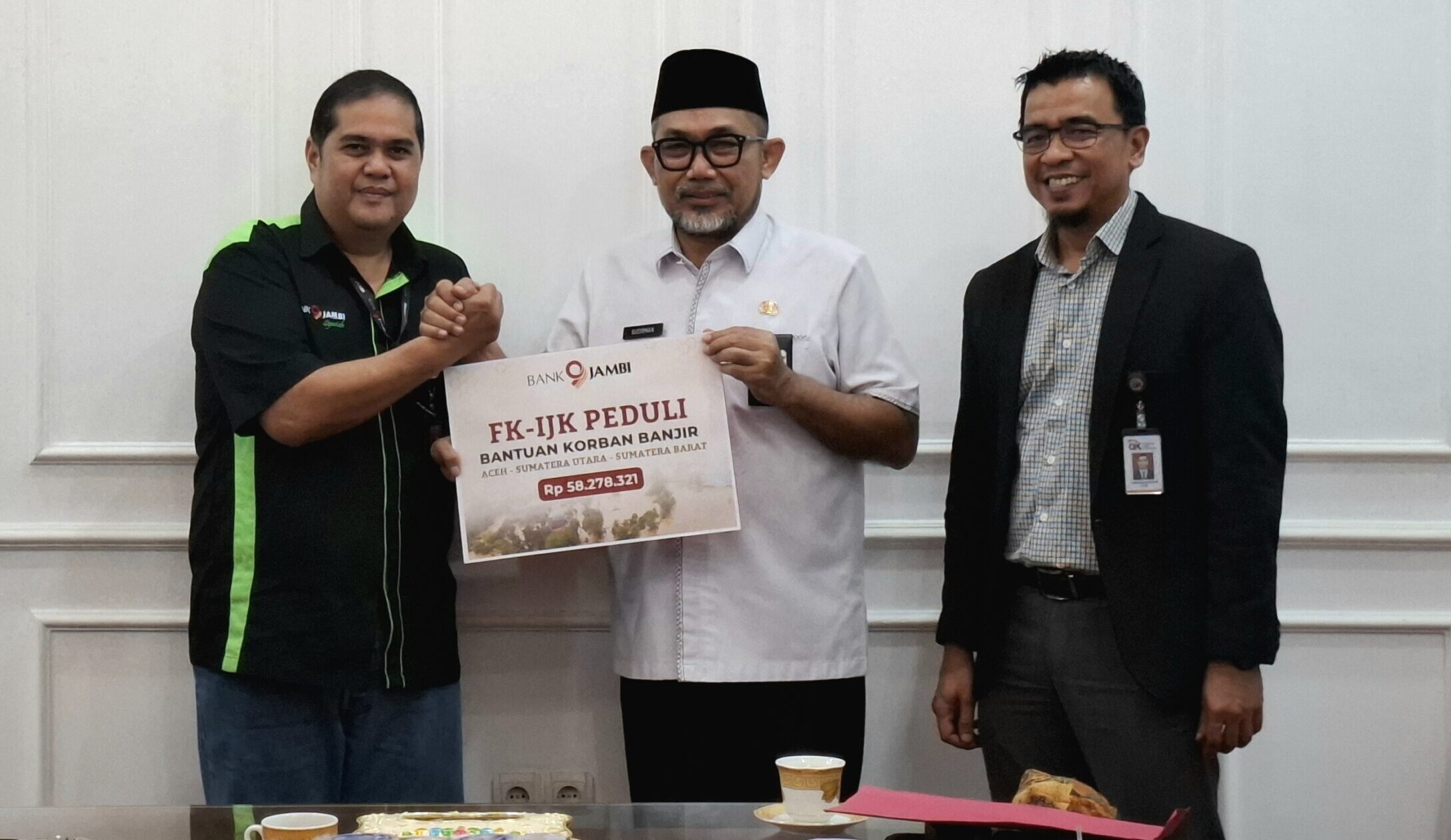 Direktur Operasional Bank Jambi, Zulfikar menyerahkan bantuan dana untuk korban bencana alam melalui pemerintah provinsi Jambi